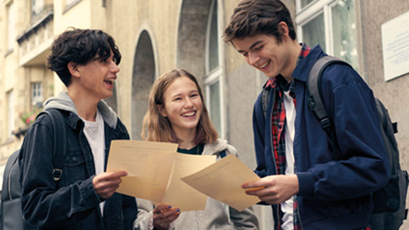 Osterferien Angebot bei der Schüllerhilfe 2 Jungs, ein Mädchen mit ihrem Zeugnis